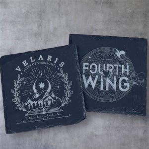 Peut inclure: Deux sous-verres en ardoise noire avec des motifs blancs. Le premier sous-verre repr&eacute;sente une lune croissante, des &eacute;toiles et des montagnes avec le texte "VELARIS CITY OF STARLIGHT." Le deuxi&egrave;me sous-verre repr&eacute;sente un cercle avec le texte "FLY...OR DIE FOURTH WING".