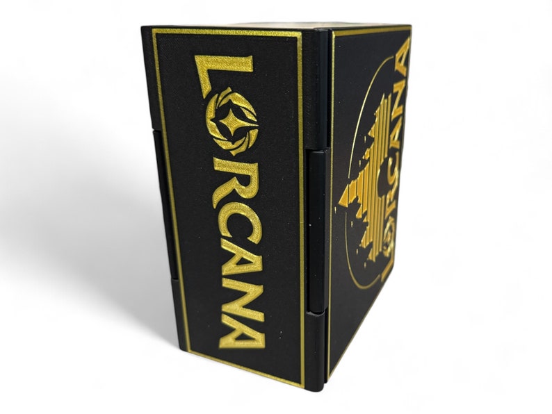 May include: Black box with gold lettering that reads "LORCANA" and a gold design on the side.