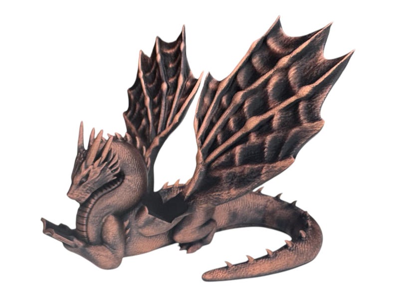 May include: A copper-colored dragon figurine with outstretched wings and a curled tail. The dragon is in a flying pose with its head turned to the side.