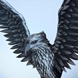 May include: A detailed sculpture of an eagle with outstretched wings. The eagle is depicted in shades of gray and black, with intricate feather detailing. The sculpture has a textured surface and a powerful, dynamic pose.
