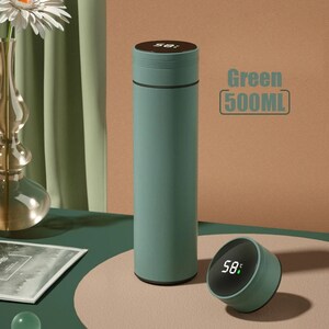 A green cylindrical thermos with a digital temperature display showing 58°C on its lid, placed on a white surface.