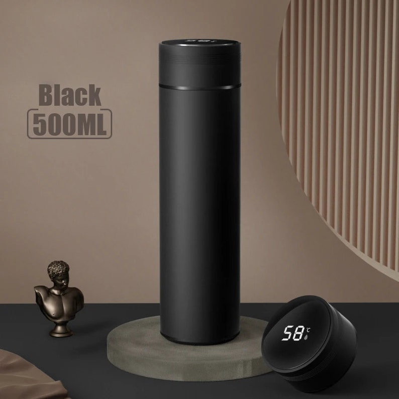 A black cylindrical thermos with a digital temperature display showing 58°C on its lid, placed on a white surface.