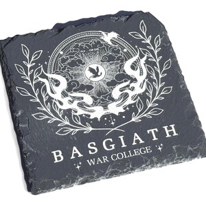 Peut inclure: Sous-verre en ardoise noire avec un motif blanc repr&eacute;sentant un oiseau stylis&eacute;, une couronne et le texte "Basgiath War College" dans un cadre circulaire.