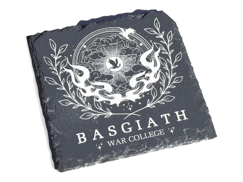 Peut inclure: Sous-verre en ardoise noire avec un motif blanc repr&eacute;sentant un oiseau stylis&eacute;, une couronne et le texte "Basgiath War College" dans un cadre circulaire.