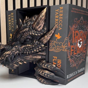 A decorative dragon bookend supporting a book, combining fantasy elements with functional design for book lovers.