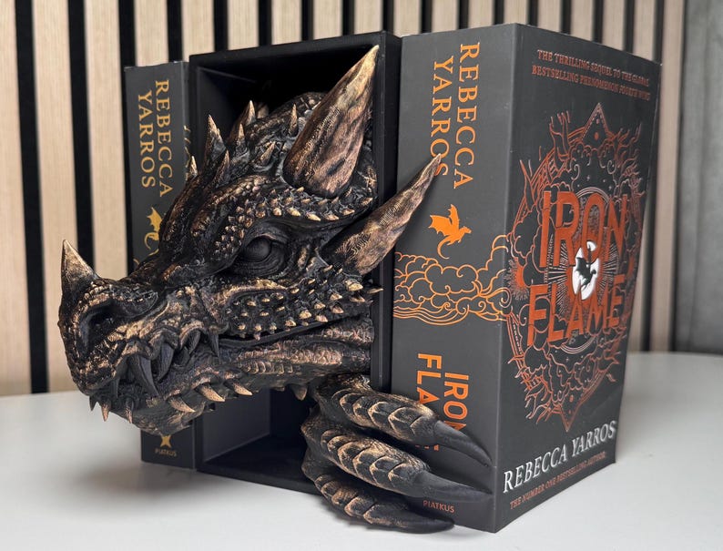 A decorative dragon bookend supporting a book, combining fantasy elements with functional design for book lovers.