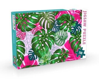 May include: A 500-piece jigsaw puzzle featuring a tropical leaf pattern with pink and green leaves on a light pink background. The box has the text "JIGSAW PUZZLE" on the side.