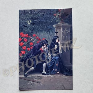 May include: A vintage print depicting a romantic scene with two figures in period clothing. A man in a purple coat and breeches bows before a woman in a blue floral gown. Red roses and bats are in the background.