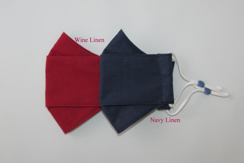 May include: Two face masks, one wine linen and one navy linen, with white ties and blue toggles.