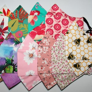 Puede incluir: Una colecci&oacute;n de 10 mascarillas de tela coloridas con varios patrones florales y geom&eacute;tricos. Las mascarillas est&aacute;n hechas de algod&oacute;n y tienen lazos para las orejas ajustables.