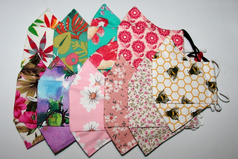 Puede incluir: Una colecci&oacute;n de 10 mascarillas de tela coloridas con varios patrones florales y geom&eacute;tricos. Las mascarillas est&aacute;n hechas de algod&oacute;n y tienen lazos para las orejas ajustables.