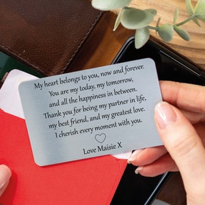 Può includere: Una carta di metallo argentato con un messaggio sentito inciso su di essa. Il messaggio recita: "Il mio cuore ti appartiene, ora e per sempre. Tu sei il mio oggi, il mio domani e tutta la felicità che c'è tra i due. Grazie per essere il mio partner nella vita, il mio migliore amico e il mio amore più grande. Apprezzo ogni momento con te. Con affetto, Maisie X"