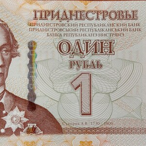 May include: A one ruble banknote from the Transnistrian Republic, featuring a portrait of Alexander Suvorov, a Russian military leader. The note is printed in shades of brown, green, and red, with the text "Приднестровье" (Transnistria) and "Один рубль" (One ruble) in Cyrillic script.