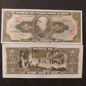 May include: A vintage Brazilian banknote with a portrait of a man in a suit and a scene of people on a beach. The note is dated 1900 and has a value of five cruzeiros.