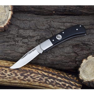 May include: A pocket knife with a black handle and a stainless steel blade. The blade is engraved with the words "Knives Ranch".