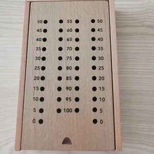 May include: A wooden box with a series of holes and numbers from 0 to 100. The box is made of light wood and has a hinged lid.