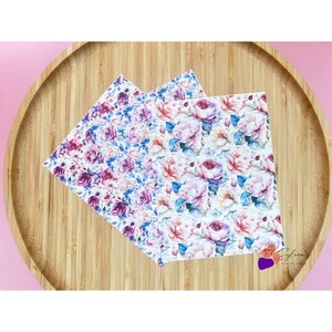 Könnte beinhalten: Drei Blätter mit floralem Muster, mit Aquarelldesign mit rosa, lila und blauen Blumen auf weißem Hintergrund.