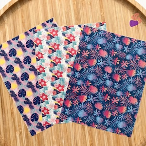 May include: Three sheets of patterned paper with tropical leaf and flower designs. The first sheet has a pink background with dark blue leaves and yellow flowers. The second sheet has a white background with pink, red, and blue flowers and green leaves. The third sheet has a dark blue background with pink, red, and blue flowers and dark blue leaves.