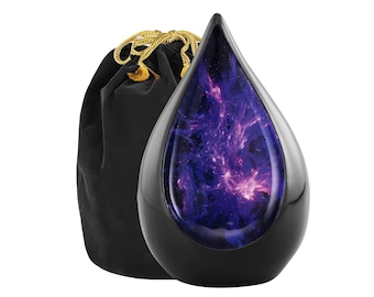 May include: Black teardrop-shaped urn with a celestial galaxy design. The urn has a glossy finish and a silver trim. A black velvet bag with a gold drawstring is next to the urn.