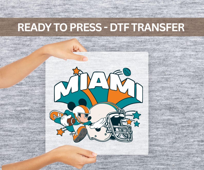 A person's hands holding a sign with a graphic of Mickey Mouse and the word "MIAMI" written on it.