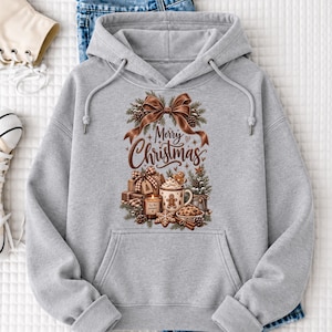 A gray hoodie with a graphic design featuring a Christmas tree, presents, and a bow, along with the text "Merry Christmas" printed on it.