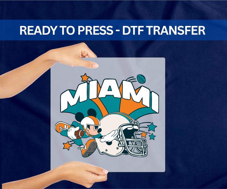 A person's hands holding a sign with the text "MIAMI" and an illustration of Mickey Mouse holding a football.