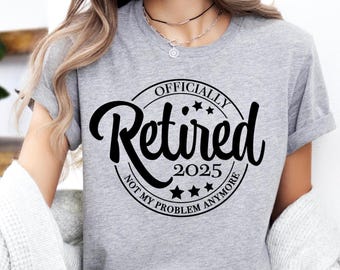 May include: A heather gray short-sleeve t-shirt featuring a black circular graphic with the text "OFFICIALLY Retired 2025 NOT MY PROBLEM ANYMORE" and five small stars. The shirt has a crew neckline and a casual fit, displaying clear black lettering.