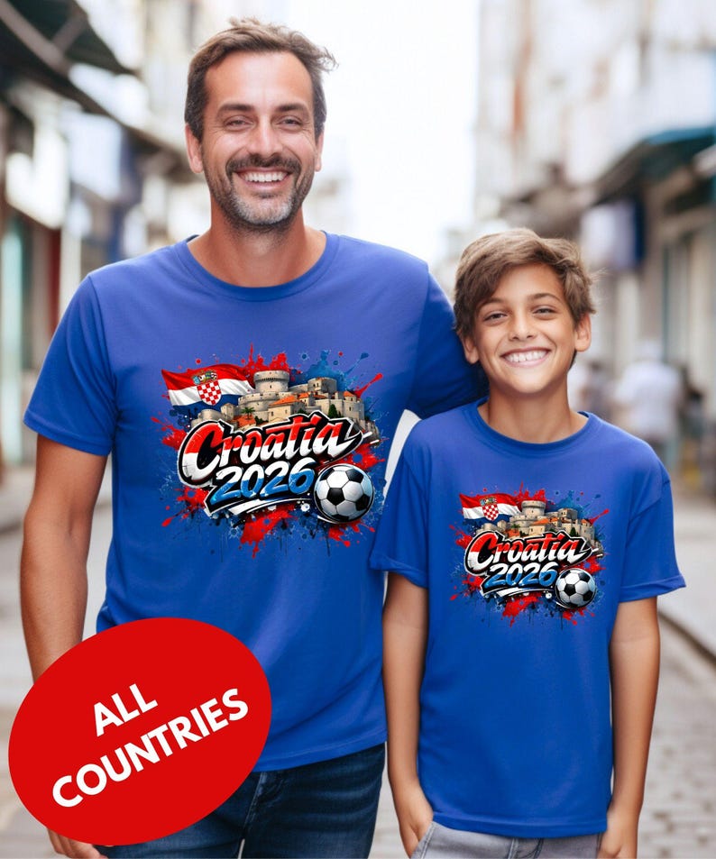 A man and a young boy are standing together, both wearing blue t-shirts with a graphic design featuring the text "Cromatia 2020" and a soccer ball.