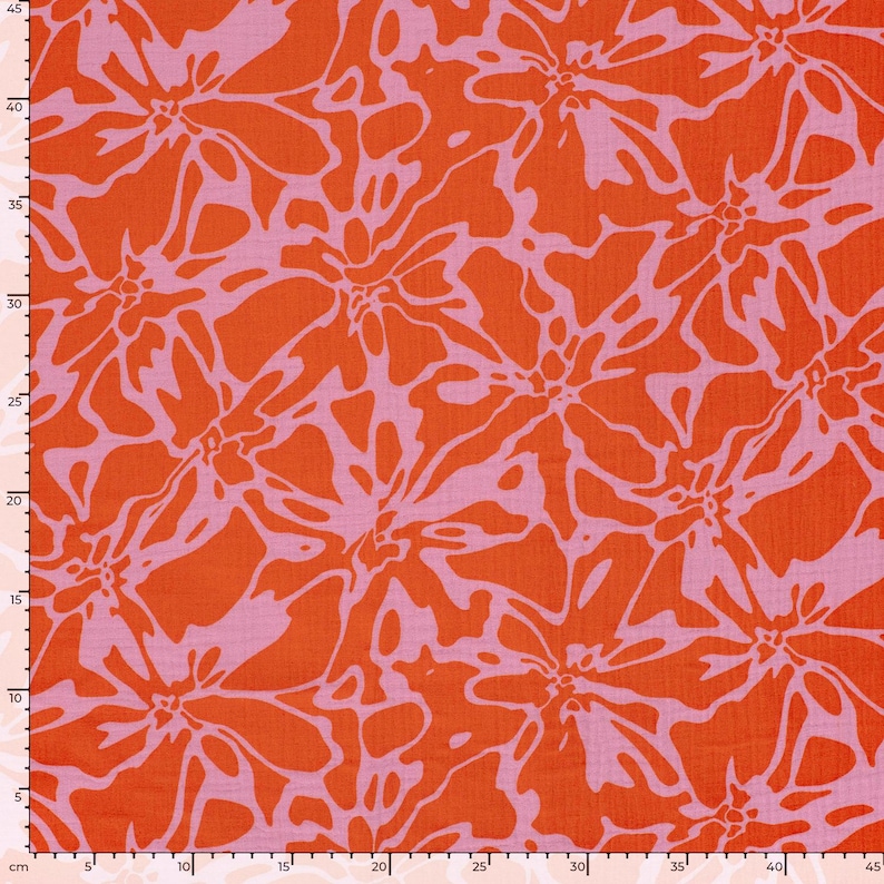 May include: A fabric featuring a repeating abstract floral pattern in vibrant orange and light pink. A metric ruler is visible along the left and bottom edges, indicating a width and height of approximately 45 centimeters for the visible section.