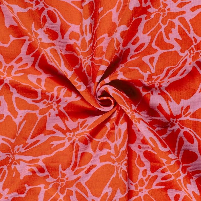 May include: A fabric featuring a vibrant orange and light pink floral pattern. The textile displays a repeating, large-scale botanical design with organic, flowing shapes that create a dense, interconnected visual texture across the surface.