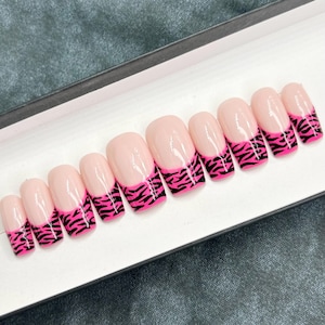 May include: Set of ten pink and black zebra print press-on nails.