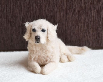May include: A handmade, off-white Golden Retriever dog sculpture. The dog is lying down on a white surface, with a brown background. The dog's fur is textured, and its eyes and nose are dark. The sculpture is detailed and realistic.