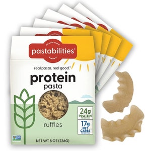 May include: A six-pack of 8-ounce packages of Pastabilities protein pasta in the flavor ruffles. Each package features a green wheat stalk, a yellow sun, and the text "real pasta. real good.™ protein pasta ruffles 24g PROTEIN PER SERVING 17g NET CARBS™ PER SERVING NET WT 8 OZ (226G)".