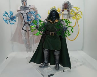 May include: Three action figures of Marvel Comics characters: Magneto in a white and blue costume, Doctor Doom in a green cape and armor, and Storm in a white and yellow costume. Each figure is holding a translucent lightning bolt effect piece.