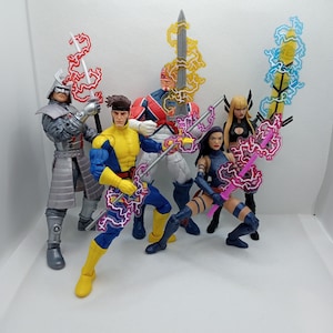 May include: A group of action figures featuring characters in dynamic poses, each holding a sword with energy effects. The figures are in various colors, including yellow, blue, silver, and red, with detailed costumes and accessories. The background is plain white.