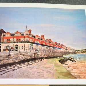 May include: A painting of a red brick building with a white trim, located on a waterfront. The building has a row of windows and a balcony. The building is surrounded by a stone wall and a cobblestone walkway. The water is blue and there are white birds in the water.