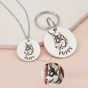 May include: Two silver dog tag pendants with a black and white husky dog illustration and the word "Puppy" engraved on each. One pendant is attached to a silver chain necklace and the other is attached to a silver key ring.