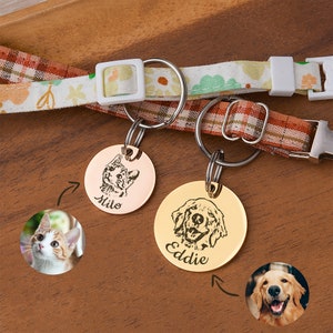 May include: Two personalized pet ID tags with engraved images of a cat and a dog. The cat tag is rose gold with the name "Milo" and the dog tag is gold with the name "Eddie".