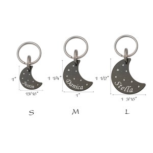 May include: Three silver crescent moon pet ID tags with engraved names "Justin", "Danica", and "Stella". The tags are available in three sizes: small (1 inch), medium (1 1/4 inches), and large (1 1/2 inches).