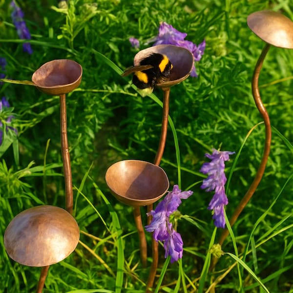 Handgefertigter Regenfänger aus Kupfer als Gartenornament.