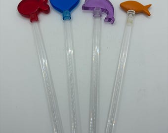 Este juego de agitadores de cóctel de acrílico de estilo vintage incluye adornos de acrílico de colores surtidos.