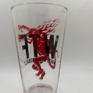 May include: Clear pint glass with a red and black graphic of a dragon-like creature with flames and the letters "FTW". The text "HELL & THE DEVIL'S" is also printed on the glass.