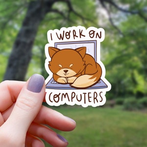 May include: A sticker with a cartoon fox sleeping on a laptop. The sticker says "I work on computers".