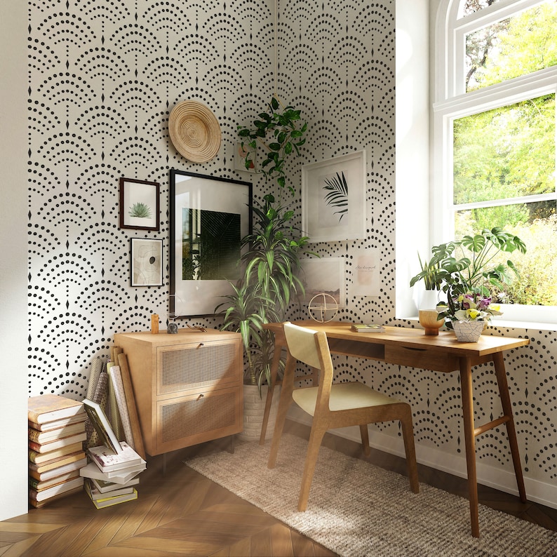 May include: A home office with a wooden desk and chair, a side table with books and a woven basket, and a wall with a black and white geometric pattern wallpaper.