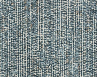 May include: A close-up of a textured fabric with a pattern of small, irregular dots. The dots are primarily in shades of blue and white, with some tan and brown accents. The overall effect is a dense, mottled appearance, suitable for upholstery or home decor.