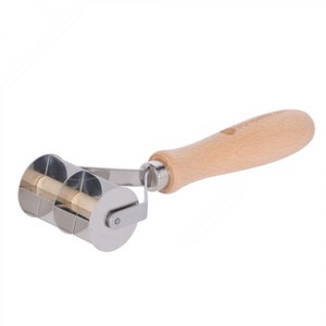 May include: A stainless steel double roller pastry cutter with a wooden handle. The roller has a decorative pattern and is used for cutting dough.