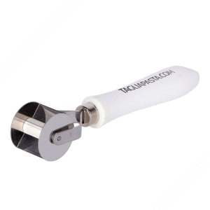 May include: A white handled pasta cutter with a silver metal wheel. The handle has the text "TAGLIAPASTA.COM" printed on it.