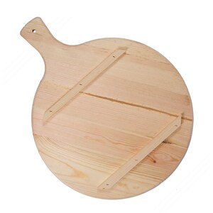 May include: A round, light-colored wooden pizza peel with a handle and a hole for hanging. The back of the peel features two wooden supports attached with small nails, providing stability and structure to the round surface.