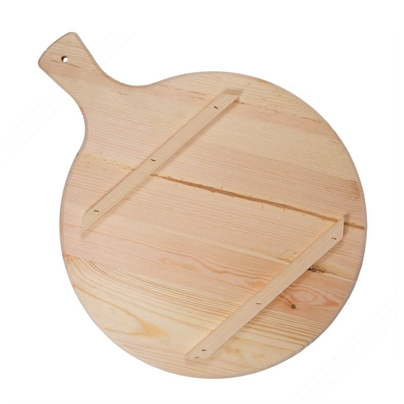 May include: A round, light-colored wooden pizza peel with a handle and a hole for hanging. The back of the peel features two wooden supports attached with small nails, providing stability and structure to the round surface.