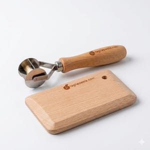 May include: A pasta cutter and a wooden cutting board. The pasta cutter has a stainless steel wheel and a wooden handle. The cutting board is rectangular and made of light-colored wood. The text "tagliapasta.com" is printed on both items.
